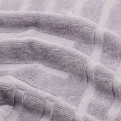 Lilac cotton towel fabric close-up with terry texture and striped pattern