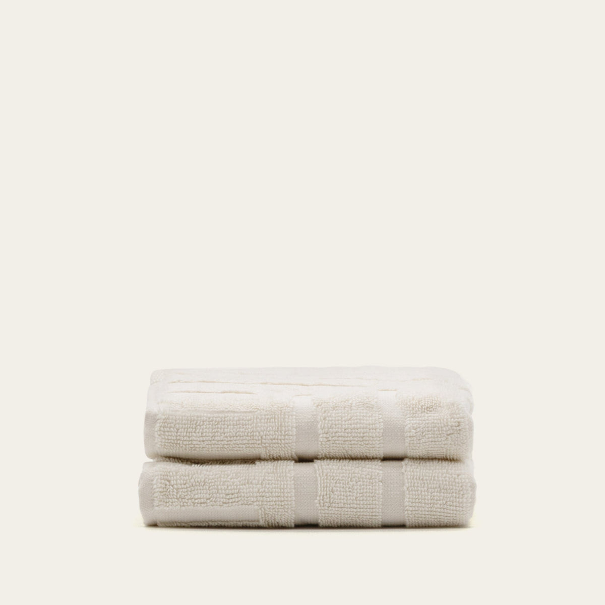 Ecru cotton towels folded with wide striped bands