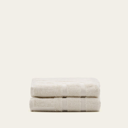 Ecru cotton towels folded with wide striped bands