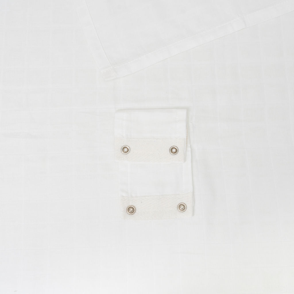 Muslin car seat cover in white with snap-button pocket detail