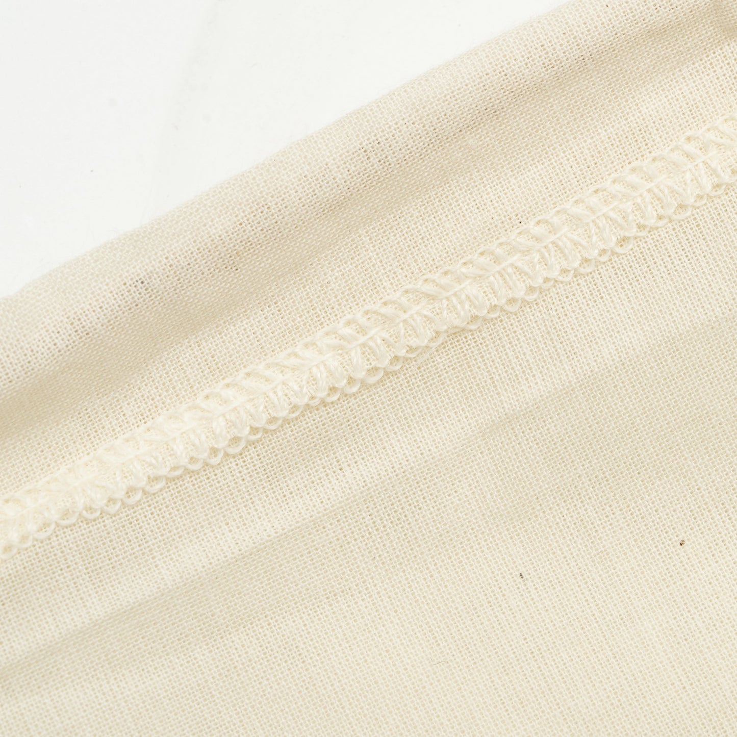 Nut milk bag edge, off-white woven mesh with gathered hem and stitched trim
