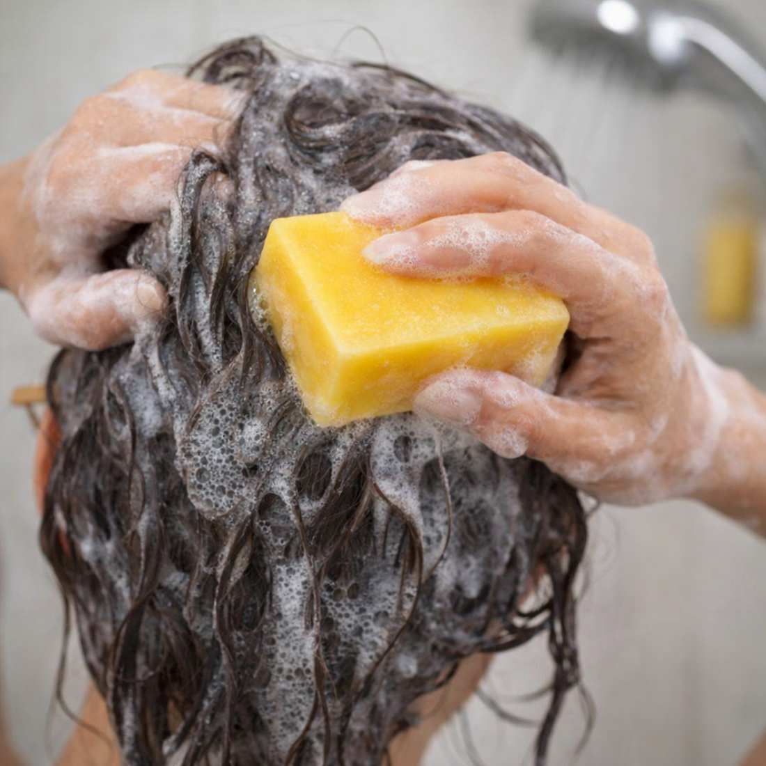 Citrus shampoo bar scrubbing wet hair with soap lather