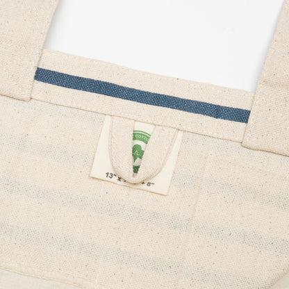 Canvas grocery tote bag label detail, beige canvas with blue stripe and inner tag
