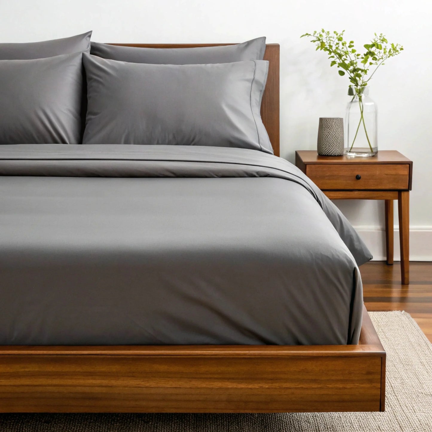 Graphite gray sheet set with matching pillowcases on a bed, close-up view.
