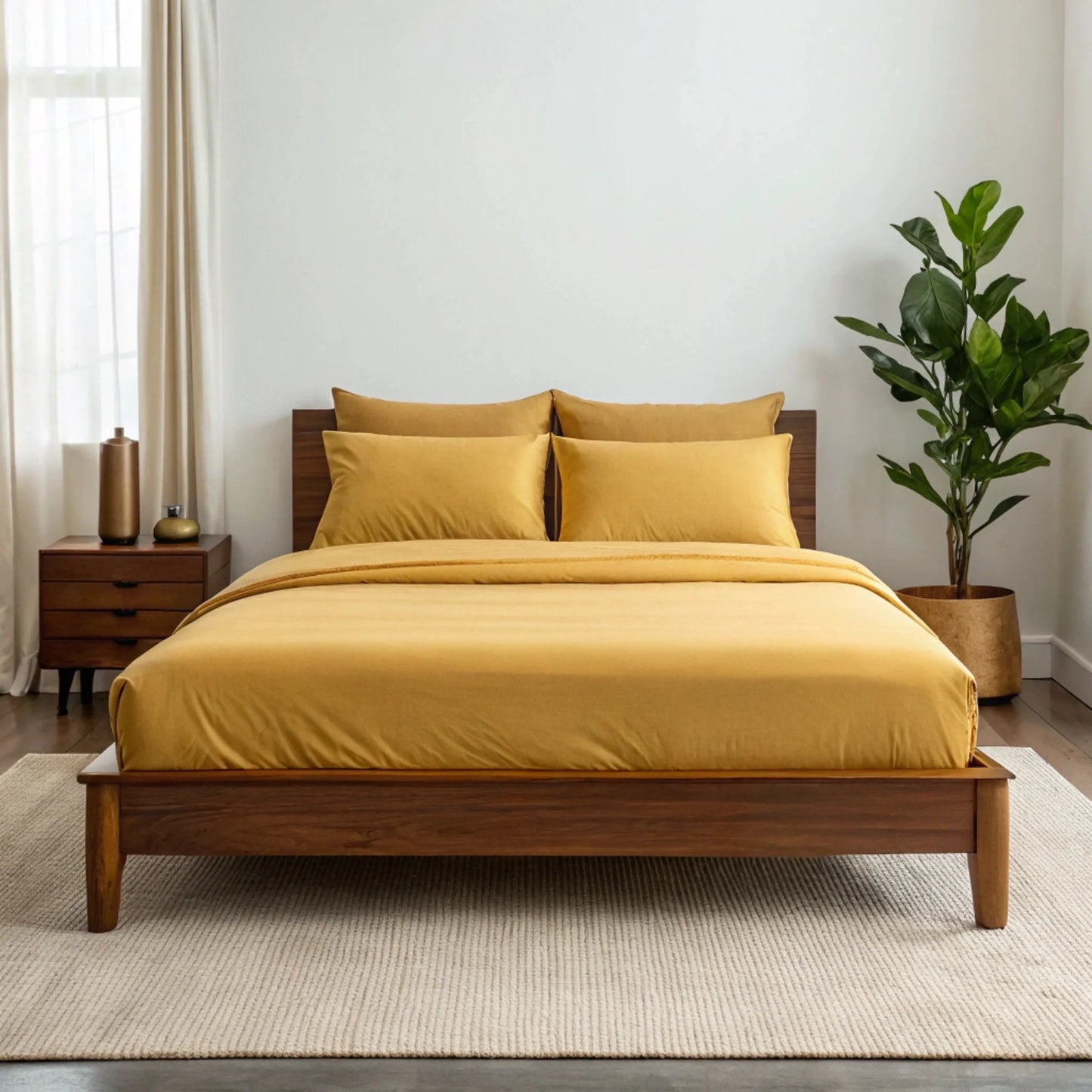 Mustard yellow sheet set with two pillowcases on a bed.