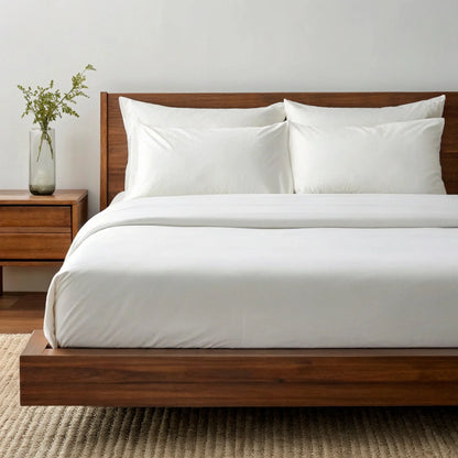 Copper-infused bamboo sheet set in powder white, neatly made bed with pillowcases