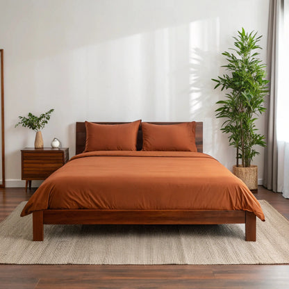 Copper-infused bamboo sheet set in rust brown, styled bed with matching pillowcases