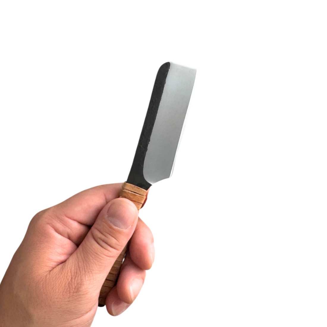 Kamisori straight razor held in hand, showing dark metal blade and wood handle