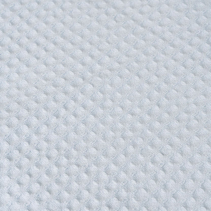 Close-up of light blue waffle weave fabric texture with small raised squares.