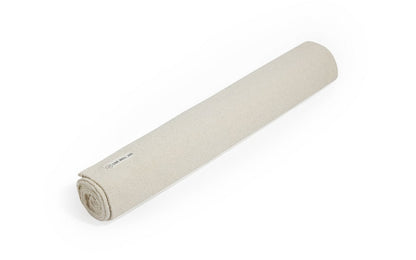 Organic cotton yoga mat, natural rolled with small fabric label on end.