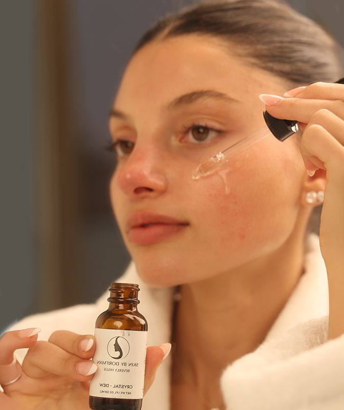 Hydrating serum bottle with black dropper during face application