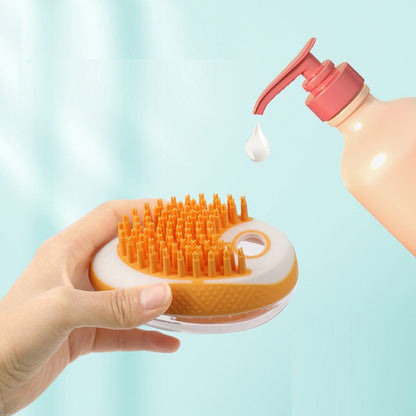 Pet bath brush with orange silicone bristles, shown with water spray