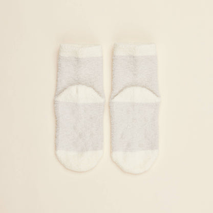 Two cream crew socks with solid design and small heart pattern near toe