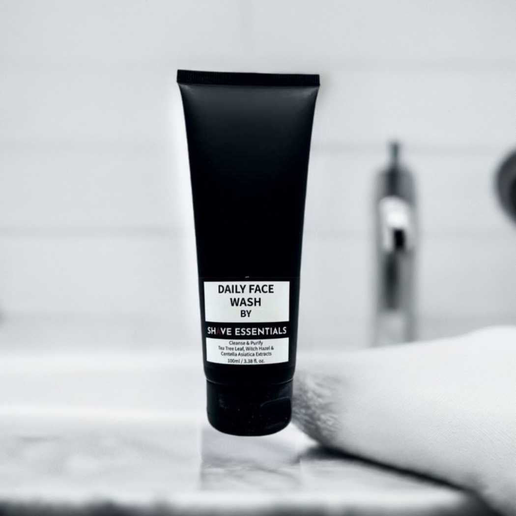 Dark face wash tube standing on a white surface