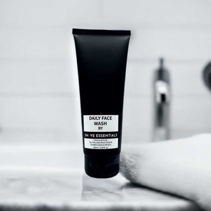 Dark face wash tube standing on a white surface