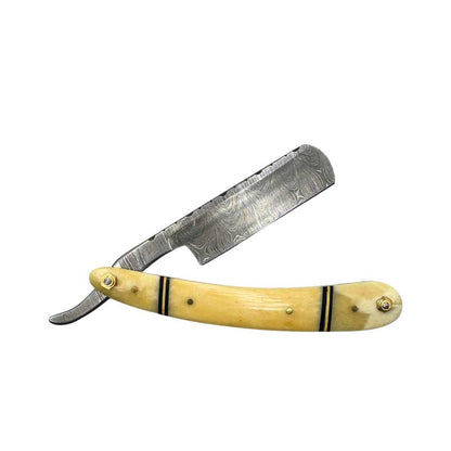 Damascus straight razor with light yellow handle, gold hardware, ridged blade