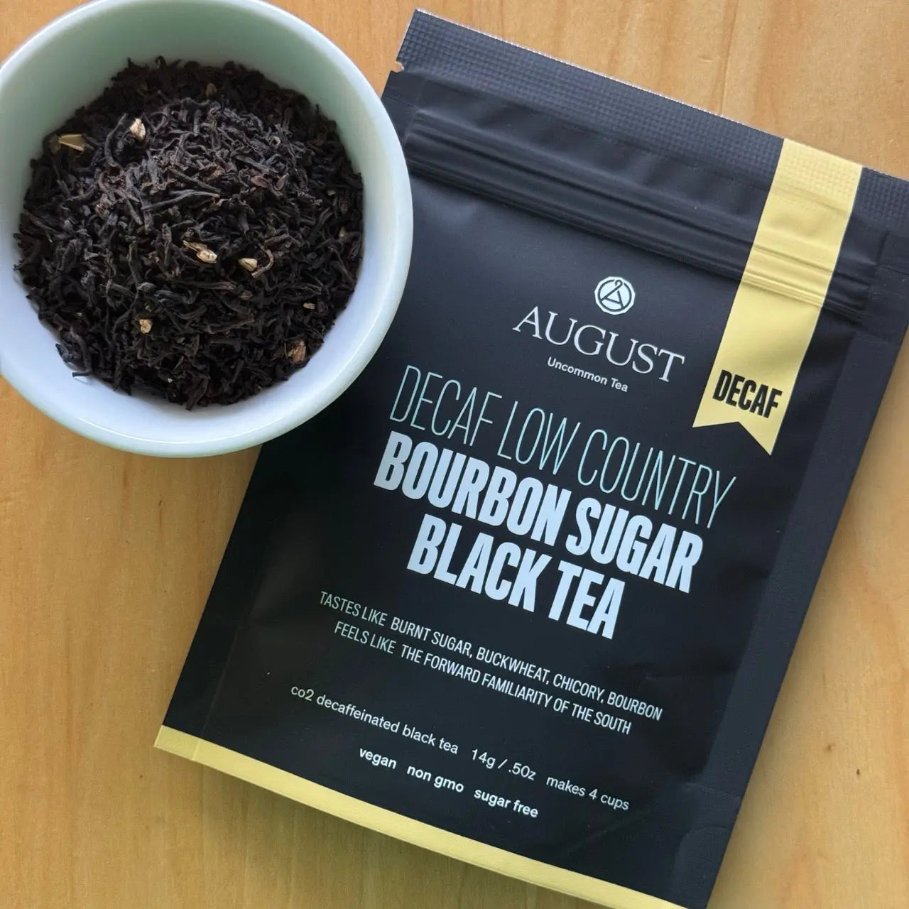 Decaf black tea pouch with bowl of loose black tea leaves