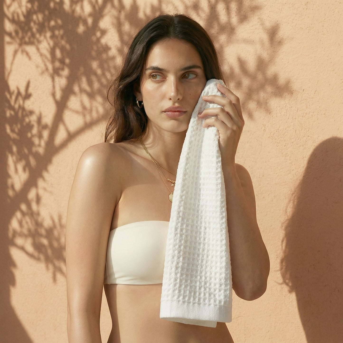 White waffle cotton hand towel held in front of a person, textured waffle surface.