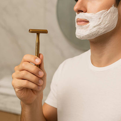 Gold double-sided safety razor held in hand