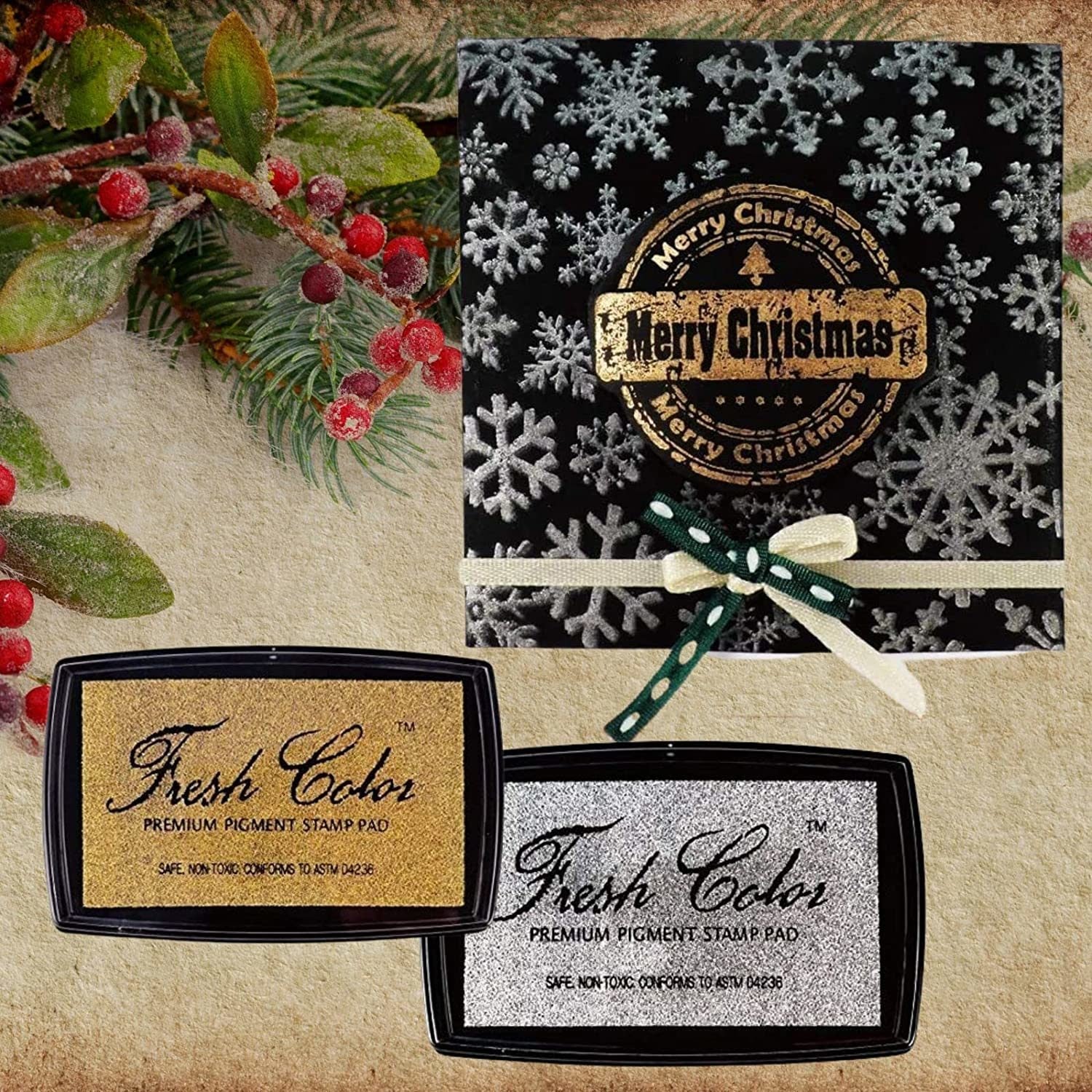 Gold and silver pigment stamp pads with festive Merry Christmas card beside them.