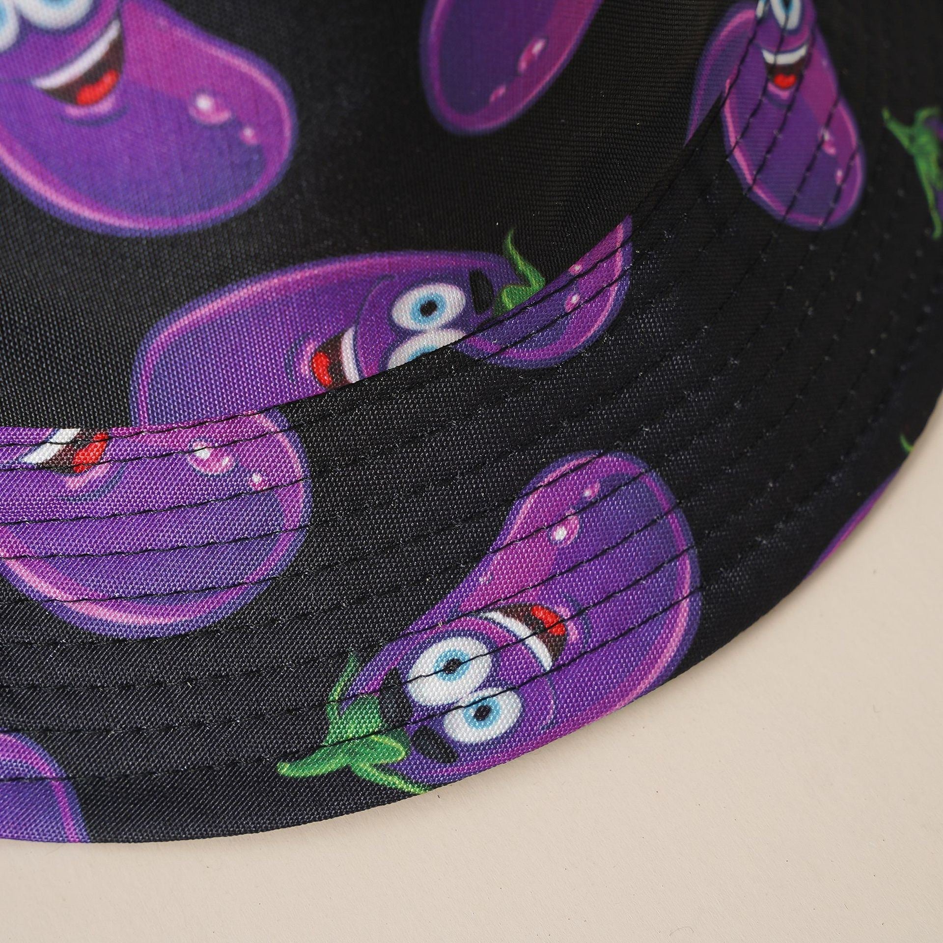 Fisherman hat black fabric with close-up purple cartoon eggplant pattern