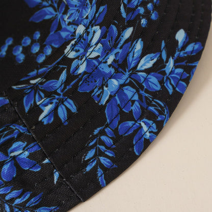 Black fabric close-up with blue floral print and visible hat stitching