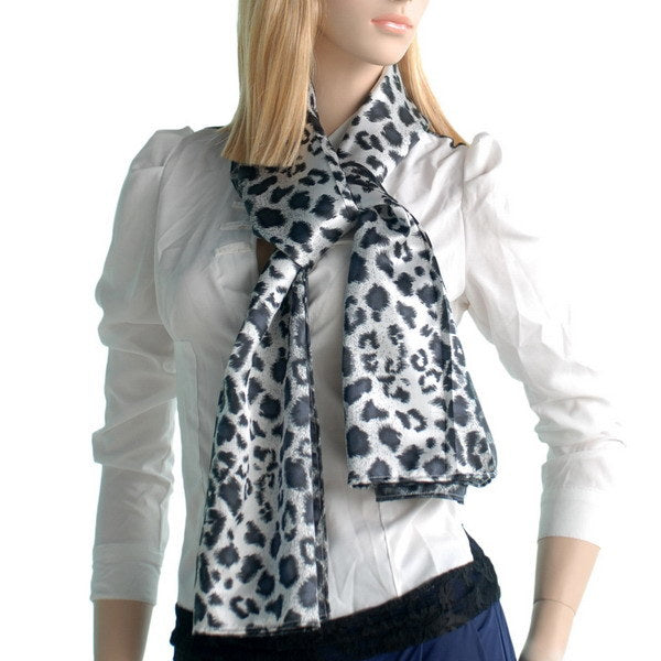 Leopard print silk scarf worn around the neck with draped ends, black and white