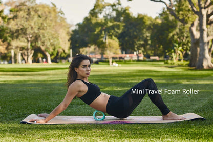 Mini travel foam roller used under legs during outdoor stretching