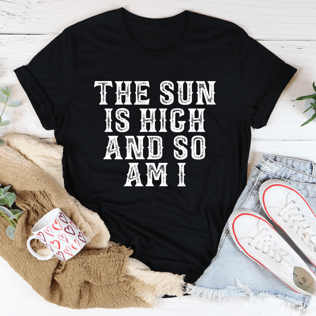 Graphic T-shirt in black with off-white centered text: THE SUN IS HIGH AND SO AM I