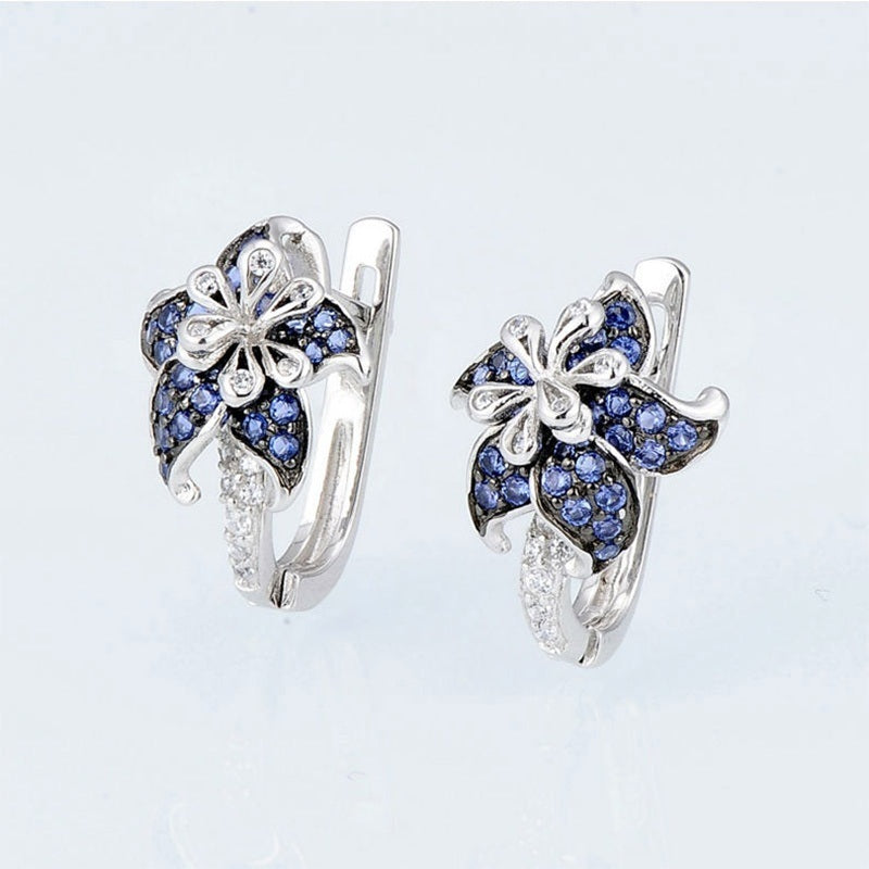 Silver-tone hinged earrings with blue double-flower clusters and clear crystal details