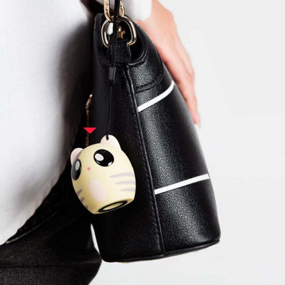 Panda Bluetooth speaker keychain hanging from a black bag