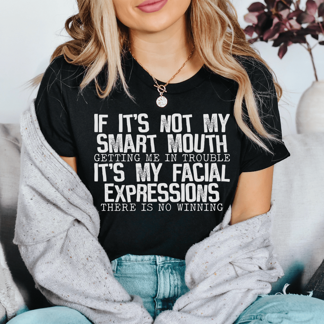Black crewneck T-shirt with centered white-and-black quote graphic: facial expressions, no winning