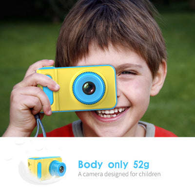 Kids mini digital video camera, blue body with yellow ring lens, held up by child