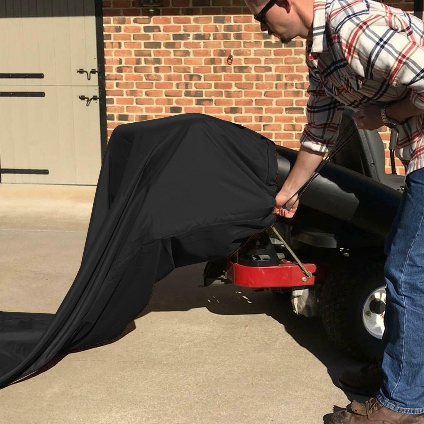 Black lawn tractor leaf bag cover being installed on mower discharge