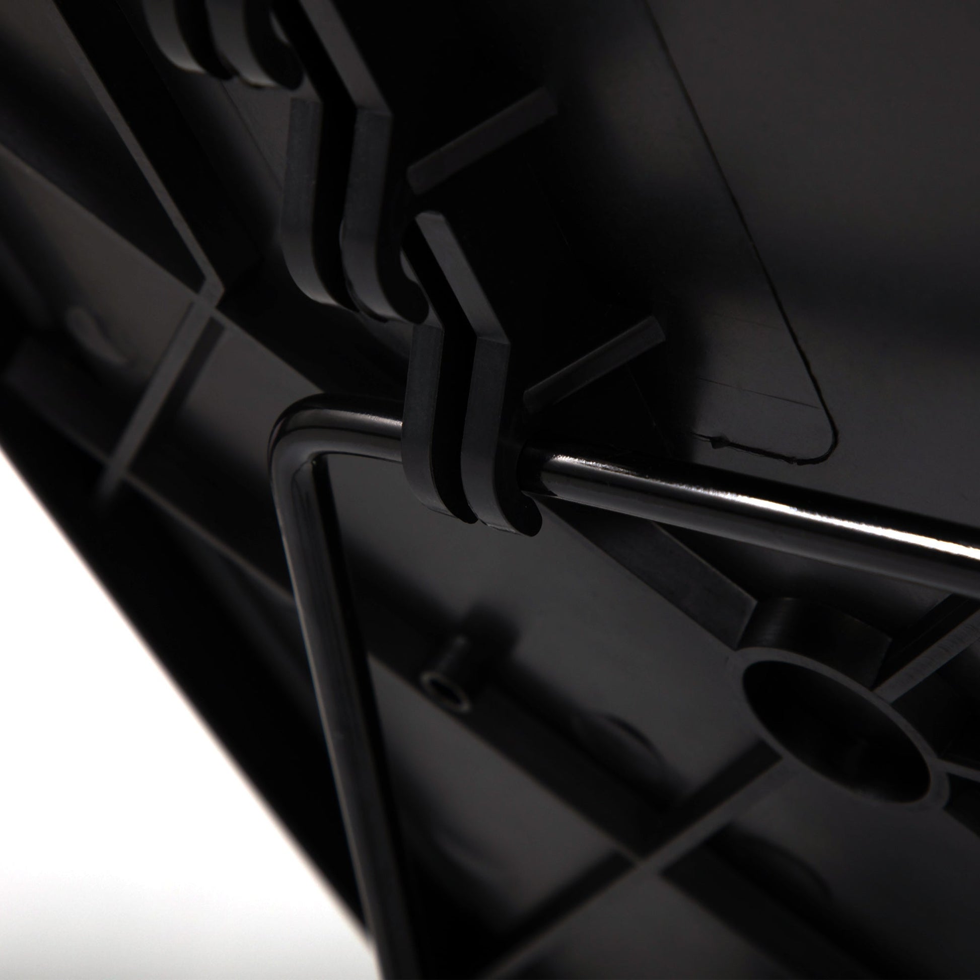 Close-up of black tray table hinge and adjustment mechanism