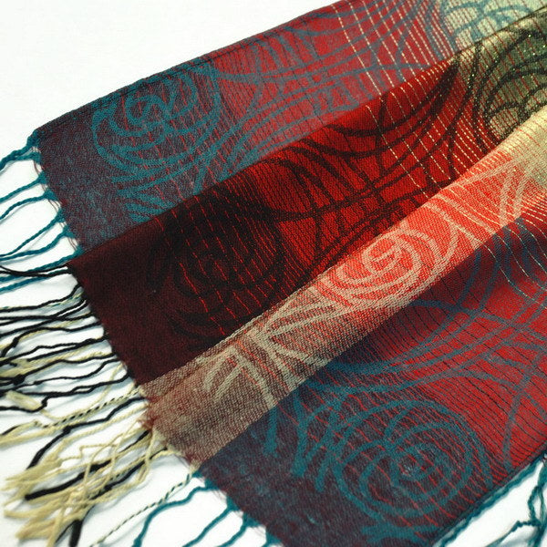 Multicolor pashmina shawl fabric close-up with red, teal, and beige patterns
