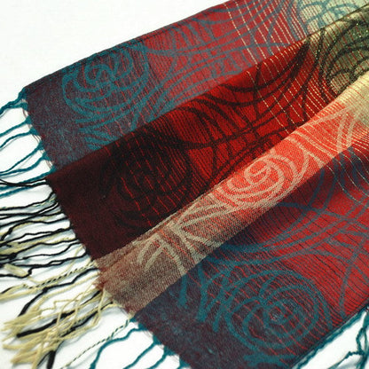 Multicolor pashmina shawl fabric close-up with red, teal, and beige patterns