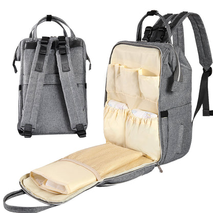 Gray diaper bag backpack with front zipper pocket and fold-open cushioned changing pad