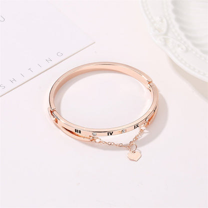 Gold stainless steel bangle bracelet with Roman numerals, small stones, heart charm