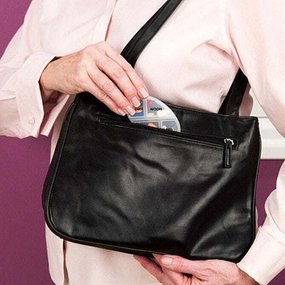 Black zippered medicine case holding a 7-day pill organizer insert
