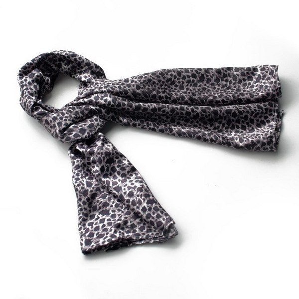 Silk scarf with dark leopard print, folded with loose ends