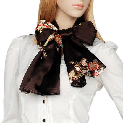 Silk floral scarf tied in a bow on the neck, dark brown with gold and red blossoms
