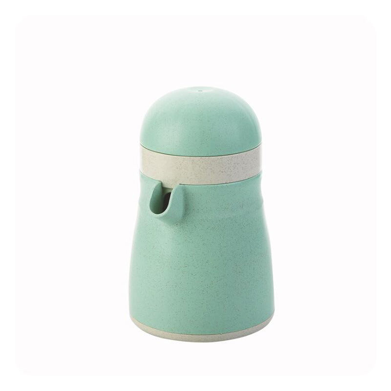 Light green manual citrus juicer with press lid, strainer, and pour spout