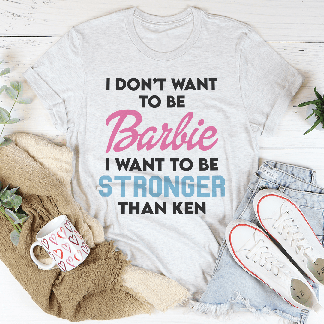 Light gray crewneck T-shirt featuring Barbie quote graphic: 'I WANT TO BE STRONGER THAN KEN'