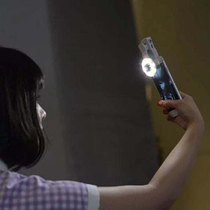 Hand holding a clip-on LED selfie light glowing on a smartphone