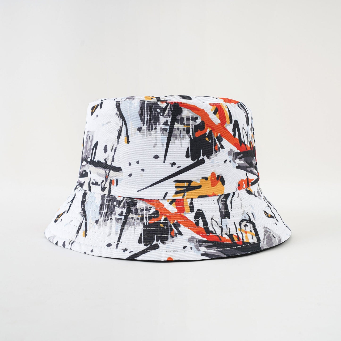 White bucket hat with graffiti print and orange accents, wide brim