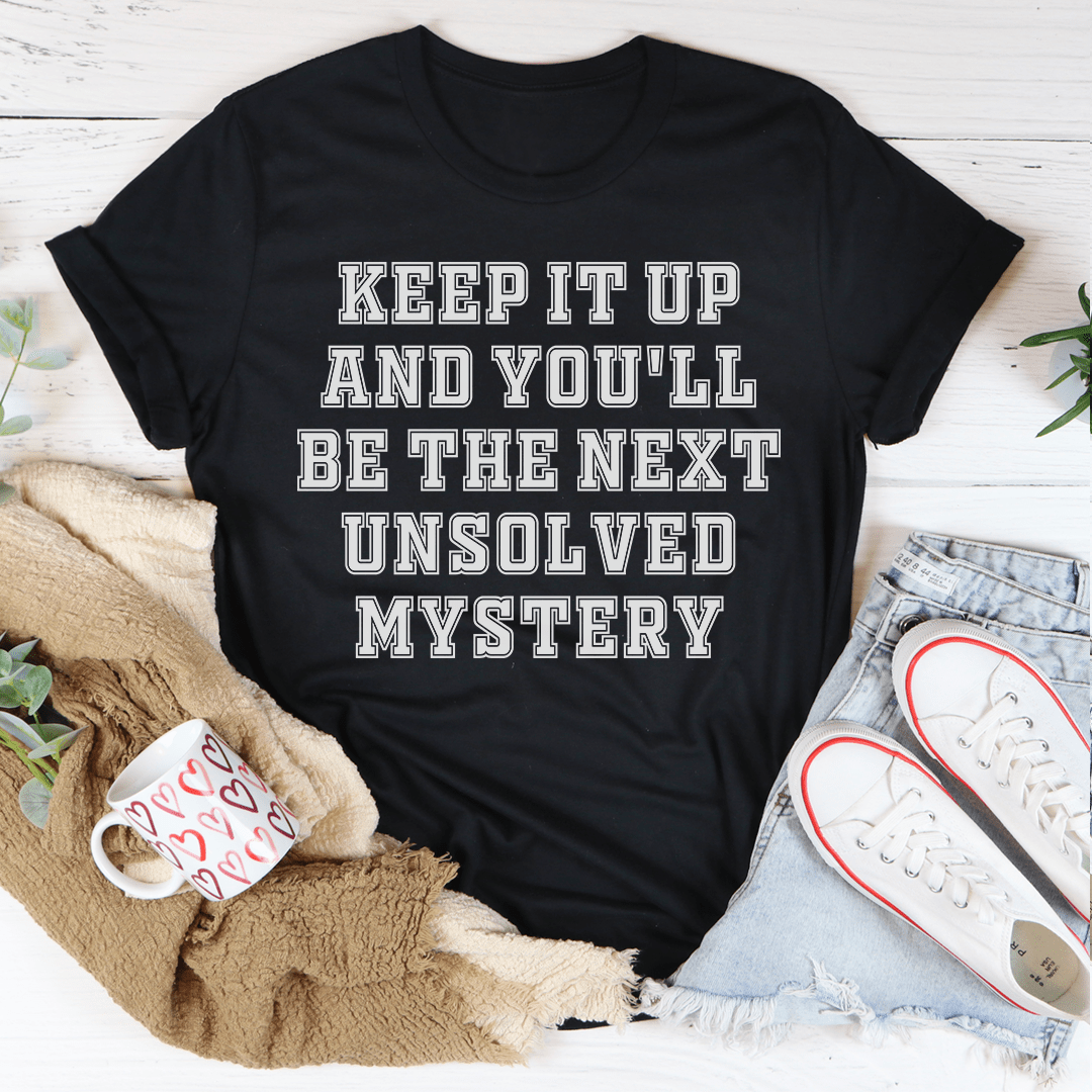 Black crewneck t-shirt with large "KEEP IT UP" and "UNSOLVED MYSTERY" text graphic