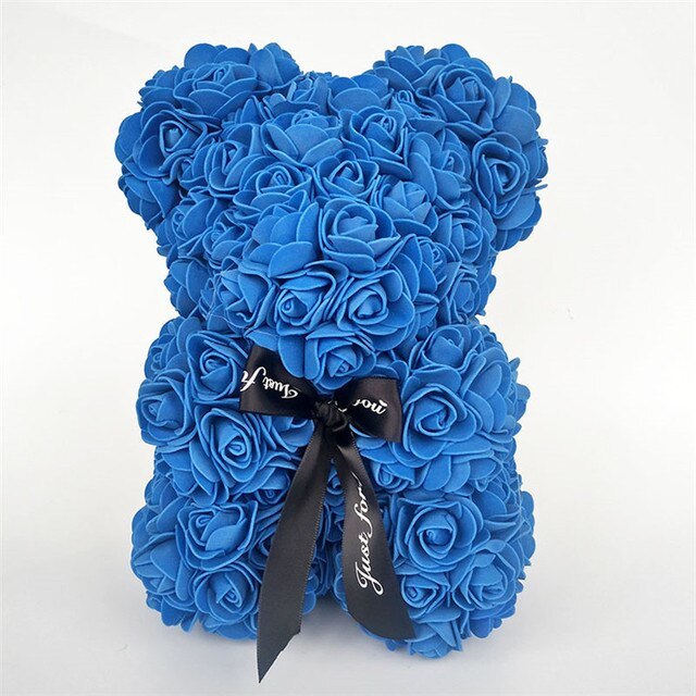Blue rose teddy bear with layered rose petals and a black ribbon bow at the center