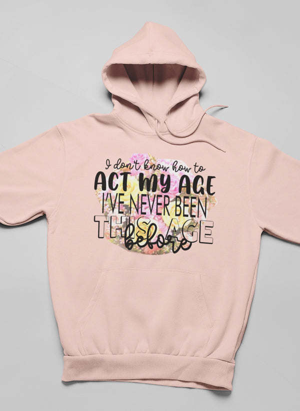 Light peach hoodie with hood and kangaroo pocket, 'Act my age' slogan print