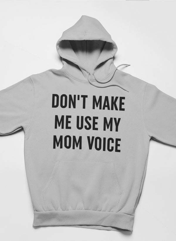 Light gray hoodie with front hood and pouch pocket; bold “DON’T MAKE ME USE MY MOM VOICE” print